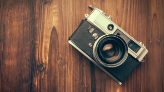 A film camera sitting on a wooden table