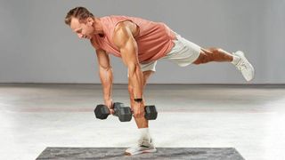 Man performing a single leg Romanian deadlift with dumbbells