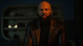 A bald, tough-looking bearded man in a leather jacket