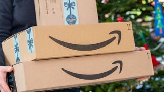 Persoon draagt Amazon-pakketjes