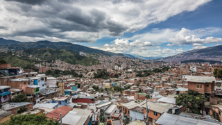 Best cameras for timelapse: Image shows a cityscape spreading across mountains, with clouds in the sky.