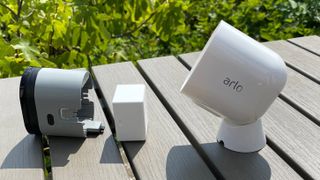 Arlo Pro 4 on a table in the garden with the casing and battery removed