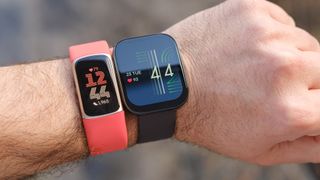 A Fitbit Charge 6 shown on a wrist next to the Amazfit Bip 5.