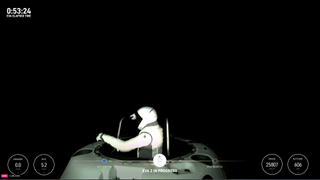 a person in a white spacesuit exits a white cone-shaped capsule into the blackness of space