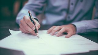 A person signing a document.