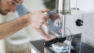 Man using coffee maker to make espresso