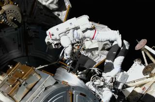 NASA astronauts Tom Marshburn (at left) and Kayla Barron are seen outside of the Quest airlock at the International Space Station during a spacewalk on Thursday, Dec. 2, 2021.