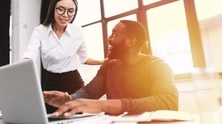 Man and woman looking at a laptop in an office