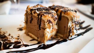 Deep fried Ice Cream on a plate drizzled in chocolate sauce