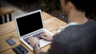 Student writing on a laptop