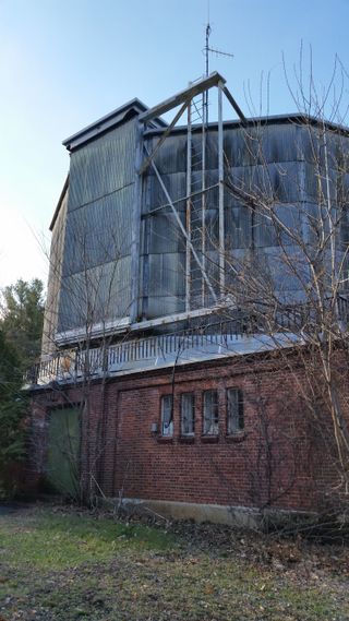 The observatory's director would climb the ladder on the side of the telescope building to grease the wheels on the section of the roof that opened up to allow the telescope to observe the sky.