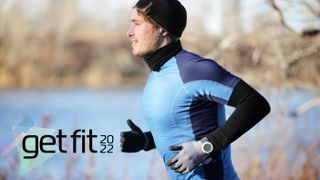 Man running in winter wearing watch, gloves, hat, and long-sleeve top