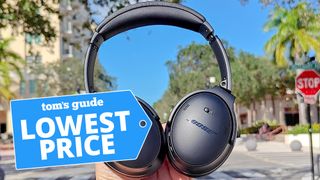 Bose QuietComfort Headphones held in front of city street 