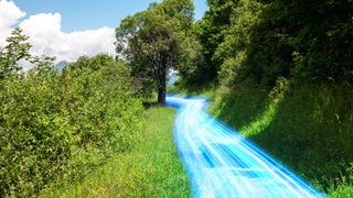 A photo of a green country path on a sunny day, with blue energy surging across the footpath representing rural broadband