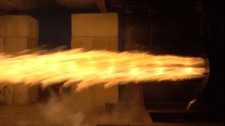 a cone of fire extends out of a metal nozzle