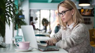 Une femme utilisant un ordinateur portable dans un café