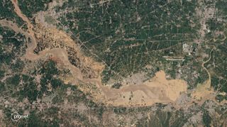 satellite image of a big brown river, whose flooding has inundated much of the landscape