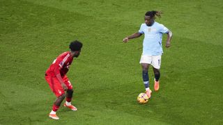 Manchester City forward Jeremy Doku takes on defender Ola Aina