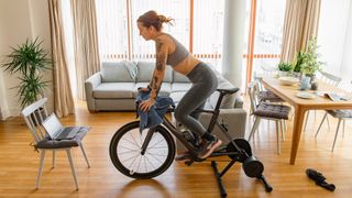 Woman cycling indoors on an exercise bike