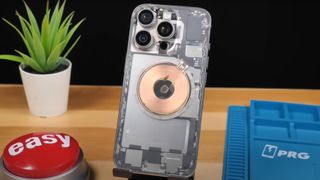 A transparent mod of the iPhone 16 Pro sitting on a desk stand