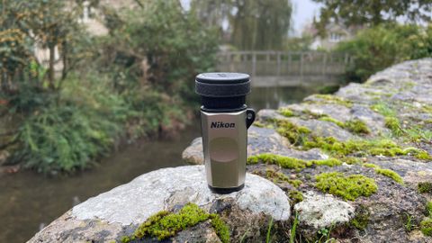 monocular on a rock next to a river