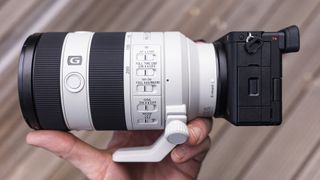 Sony FE 70-200mm F4 Macro G OSS II lens in the hand attached to Sony A6700