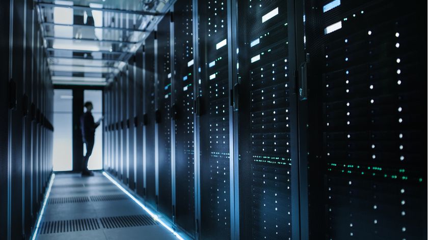 A person standing in front of a rack of servers inside a data center