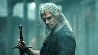 Henry Cavill as Geralt of Rivia holding a sword during the Netflix fantasy series, The Witcher.