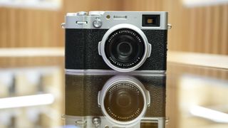 Front of the Fujifilm X100VI reflected in glass table