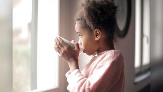 A girl drinks from a mug