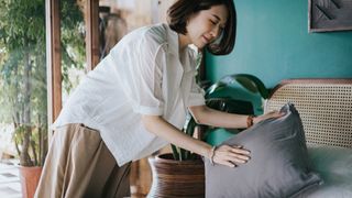 Woman fluffing up a pillow