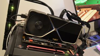 An Nvidia GeForce RTX 4080 on a wooden desk in front of a white panel