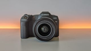 Canon EOS R8 set against a white backdrop with orange glow