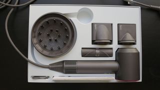 The Dyson Supersonic hair dryer and its attachments in the box