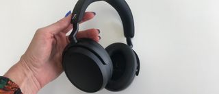 Et par hodetelefoner av typen Sennheiser Momentum 4 Wireless i en hånd.