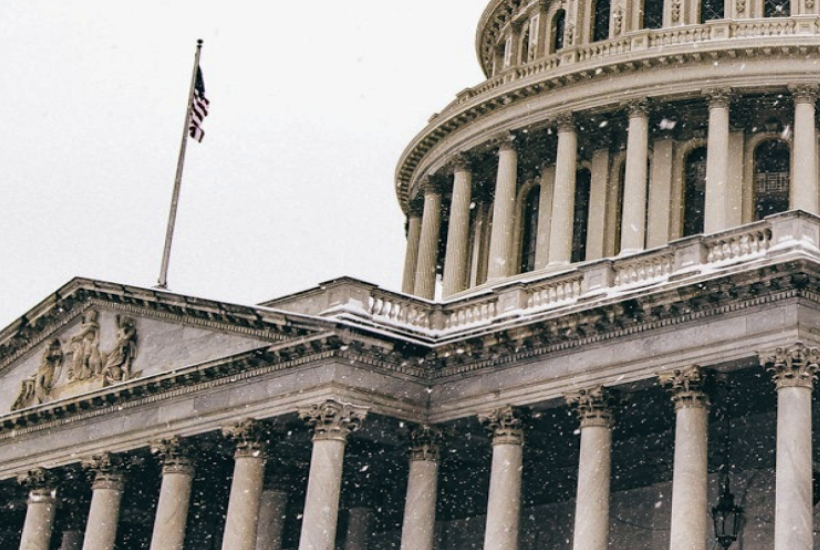 Close-up photograph of the United States Capitol building with snow falling