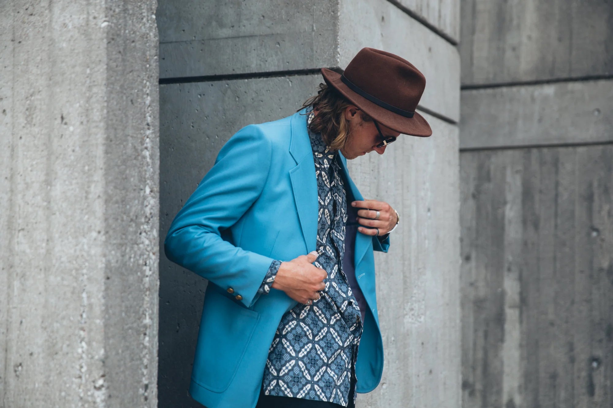 A  man poses in a dapper outfit and a hat