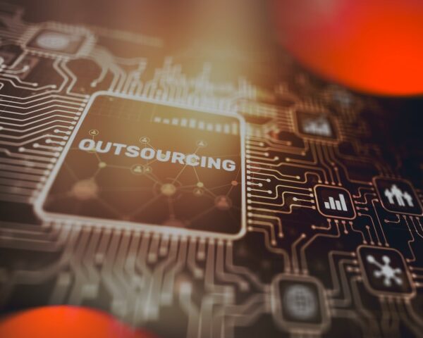 Close-up of a computer chip with the word outsourcing on it