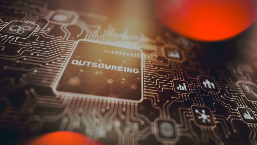 Close-up of a computer chip with the word outsourcing on it