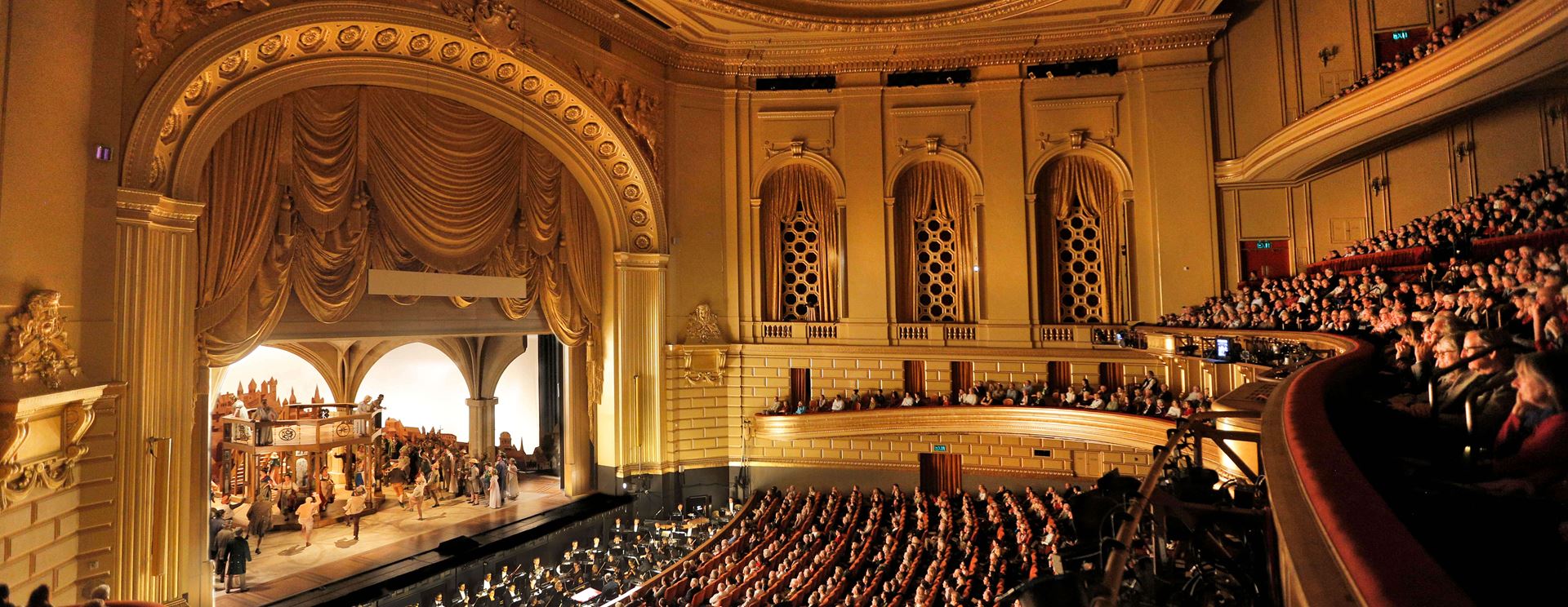 A large auditorium with many people sitting in it