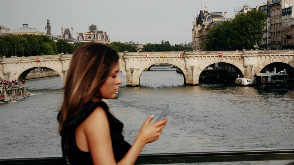 Photo: A woman is checking her phone while walking, in Paris. Credit: Steven Lasry via Unsplash.