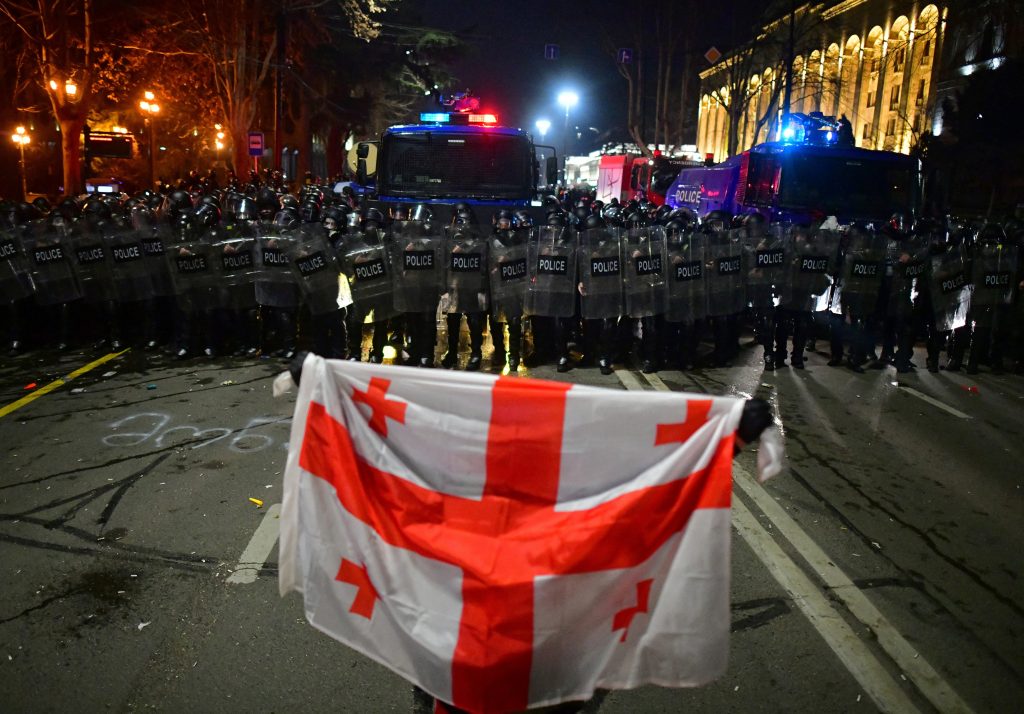 Photo: A demonstrator holds a Georgian flag in front of police officers during a protest against a draft law on "foreign agents", which critics say represents an authoritarian shift and could hurt Georgia's bid to join the European Union, in Tbilisi, Georgia, March 9, 2023. Credit: REUTERS/Zurab Javakhadze