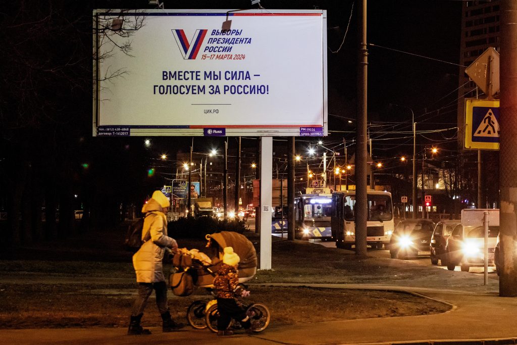 Photo: A woman with a stroller and children walks down the street against the backdrop of an advertising billboard informing about the presidential elections in Russia on March 15-17 with the inscription ìTogether we are a force - vote for Russiaî in St. Petersburg. Credit: Reuters