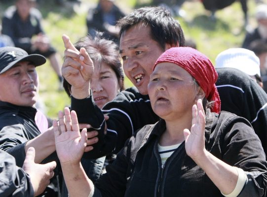 Photo: A man and a woman gesture as they gather with others at the settlement of Nizhnaya Alaarcha outside Bishkek, April 20, 2010. Kyrgyz security forces confronted a crowd massing on the outskirts of the capital Bishkek on Tuesday where looters have attacked homes belonging to mainly ethnic Russian and Meskhetian Turks. Credit: REUTERS/Vladimir Pirogov