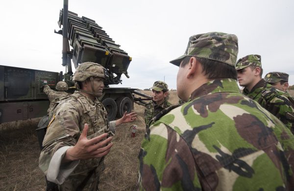 Photo: US Army Sgt. 1st Class Julio Vitela (left), with the 5th Battalion 7th Air Defense Artillery Regiment, briefs members of the Romanian Air Force on “Patriot” Missile Launcher capabilities during a “Patriot Shock” exercise in Capu Midia, Romania on November 7, 2016. The weeklong exercise tests the unit’s quick response deployment readiness and increases joint interoperability with “Patriot” missile systems and their Romanian partners. Credit: Tech. Sgt. Brian Kimbal/DoD News.