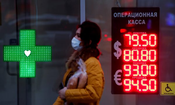 Photo: Woman walks past a board showing currency exchange rates of the euro and U.S. dollar against the Russian rouble in Moscow, Russia November 2, 2020. Credit: REUTERS/Maxim Shemetov