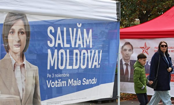 Photo: People walk past campaign tents of Moldova's incumbent President and presidential candidate Maia Sandu and presidential candidate Alexandr Stoianoglo in Chisinau, Moldova October 30, 2024. The sign on a tent reads: "Let's save Moldova!" Credit: REUTERS/Vladislav Culiomza