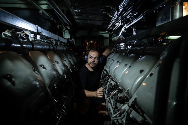 Photo: Seaman Adrian Doblas working in the engine room of the Spanish submarine ESPS Mistral during the NATO exercise Dynamic Mariner 19. The NATO-led exercise runs until 18 October 2019 and involves forces from 18 NATO Allies, testing the readiness of the naval component of the NATO Response Force (NRF). The NRF provides a quick response to any potential threat from land, air or sea. Thirty-two ships, two submarines and 18 aircraft are participating in the drills off the coast of Spain, proving their ability to work together in a crisis response scenario. Credit: NATO via Flickr. https://flic.kr/p/2hC9GtT