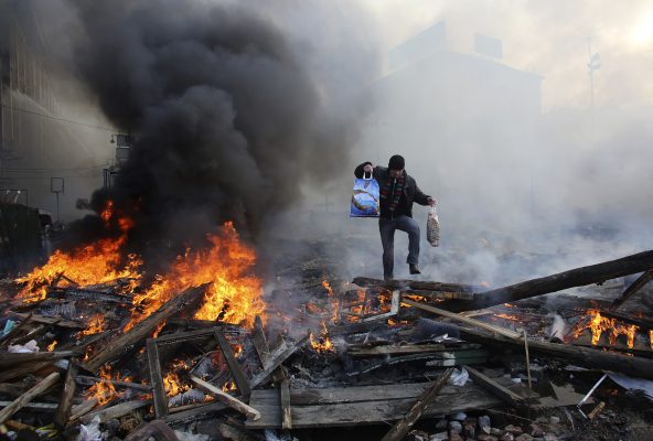 Photo: A man walks amidst burning remains of fires at Independence square in Kyiv February 21, 2014. Ukrainian President Viktor Yanukovich on Friday signed an agreement with three opposition leaders to end a crisis that sparked violent clashes between protesters and police on the streets of the capital Kyiv. Credit: REUTERS/Konstantin Chernichkin