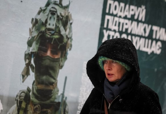 Photo: A woman walks past an advertising poster depicting a Ukrainian serviceman during a snowfall in Kyiv, Ukraine November 27, 2023. Credit: REUTERS/Gleb Garanich